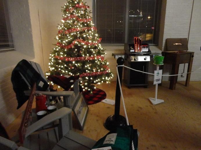 A Christmas tree on the grille of a red truck